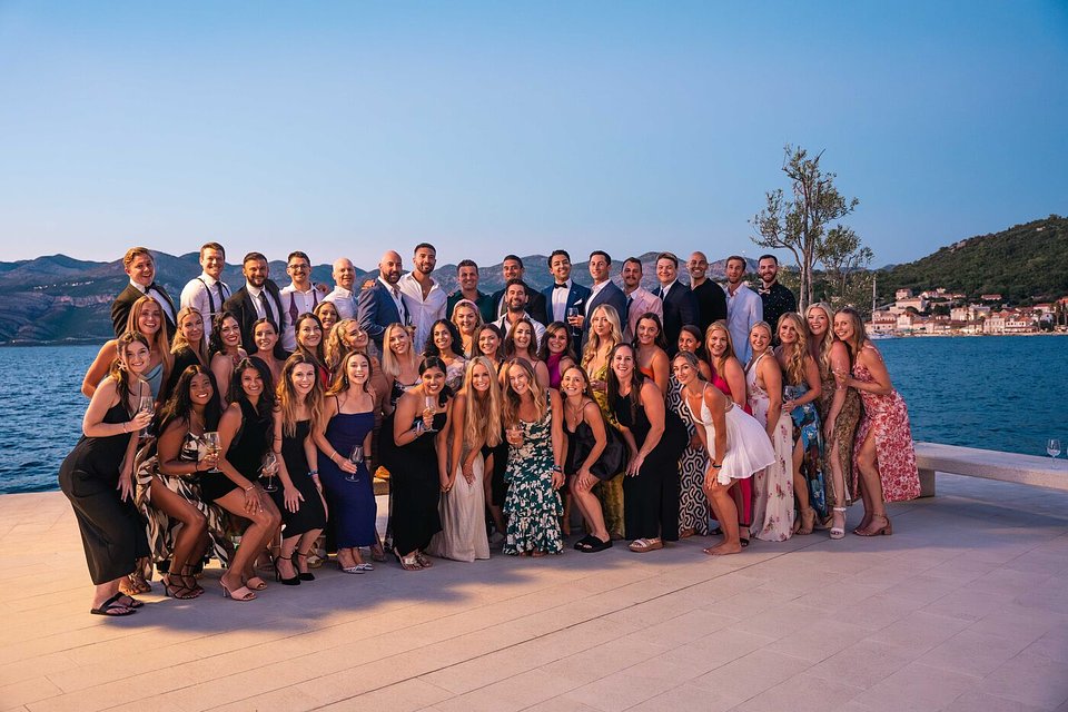 An SYB group in formal wear by the sea at dusk in Croatia