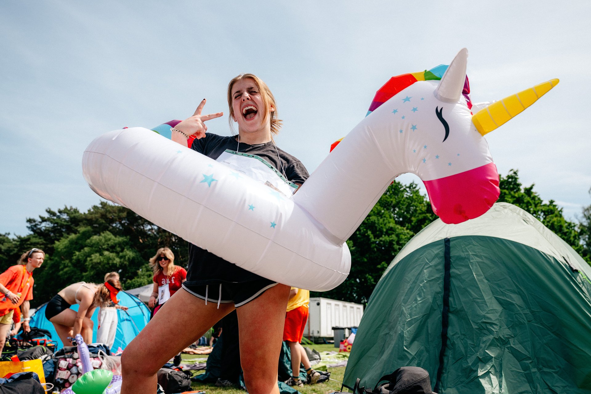 Girl with unicorn poses in the camping area at Bournemouth 7s Festival