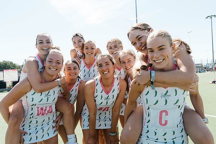 Netball team jumping on the courts at Bournemouth 7s Festival, in Dorset England.