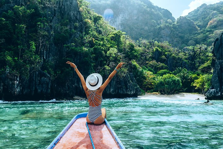 girl celebrating on a boat el nido philippines beaches
