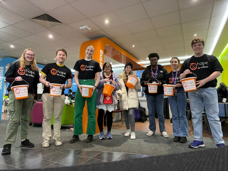 Fundraisers in matching T-shirts holding collection buckets