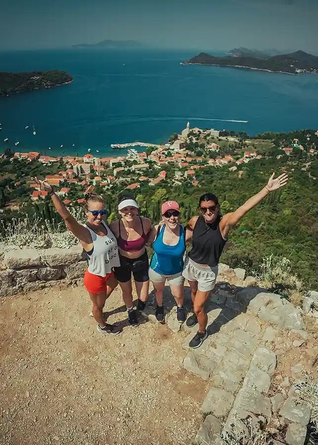 Four SYB travelers on a hilltop above the Adriatic and the islands