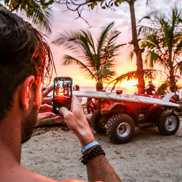sexy male traveller taking photo of santa teresa beach_Costa rica