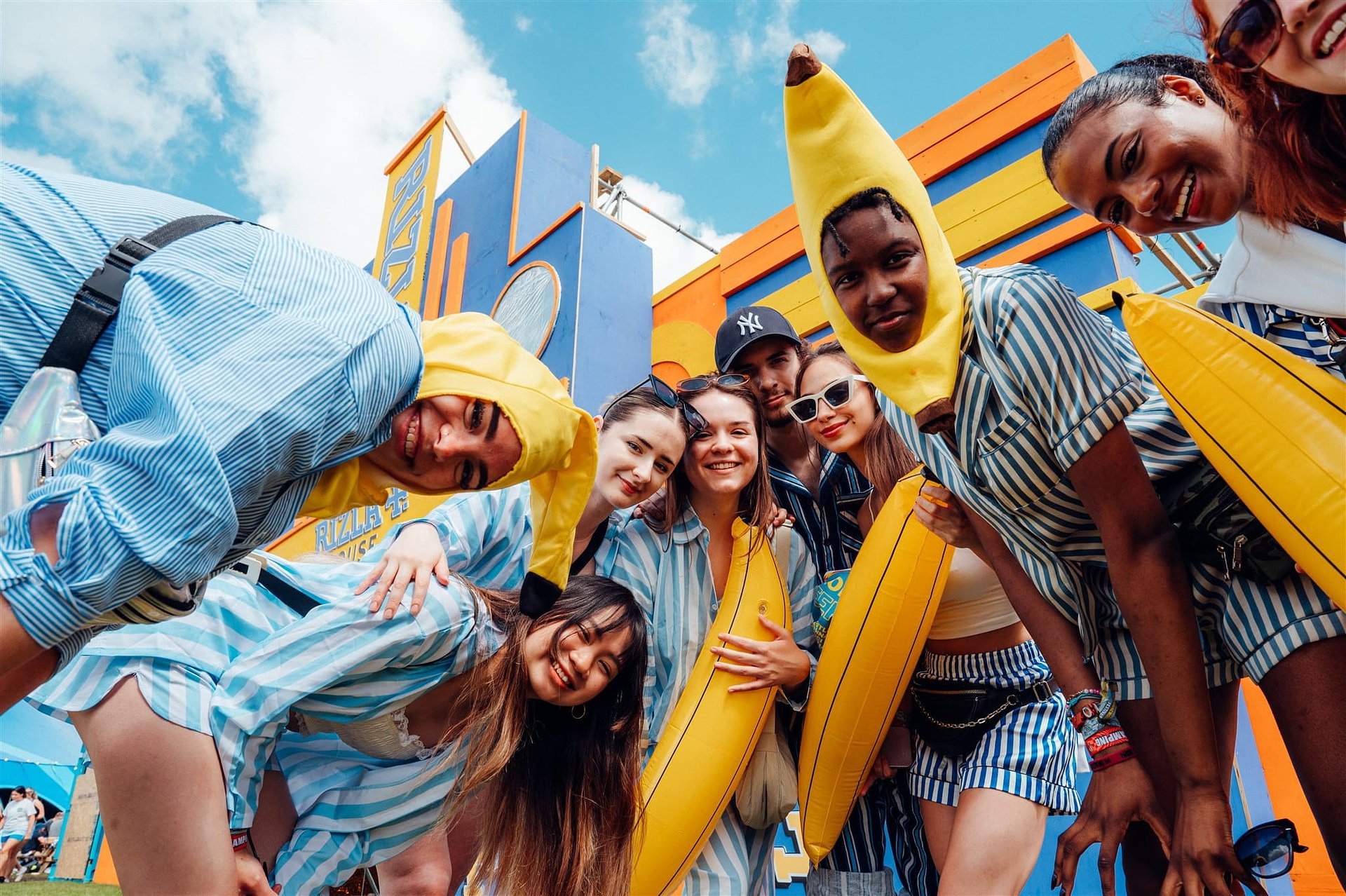 Group of sport players dressed as bananas in pyjamas fancy dress gather around the camera at Bournemouth 7s Festival, in Dorset
