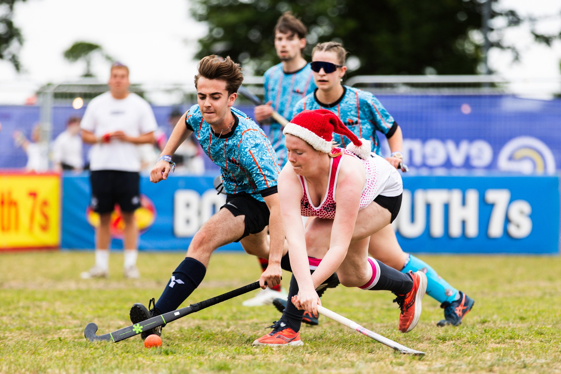 Two players compete for the ball with their sticks during a mixed hockey tournament at Bournemouth 7s Festival, in Dorset England.