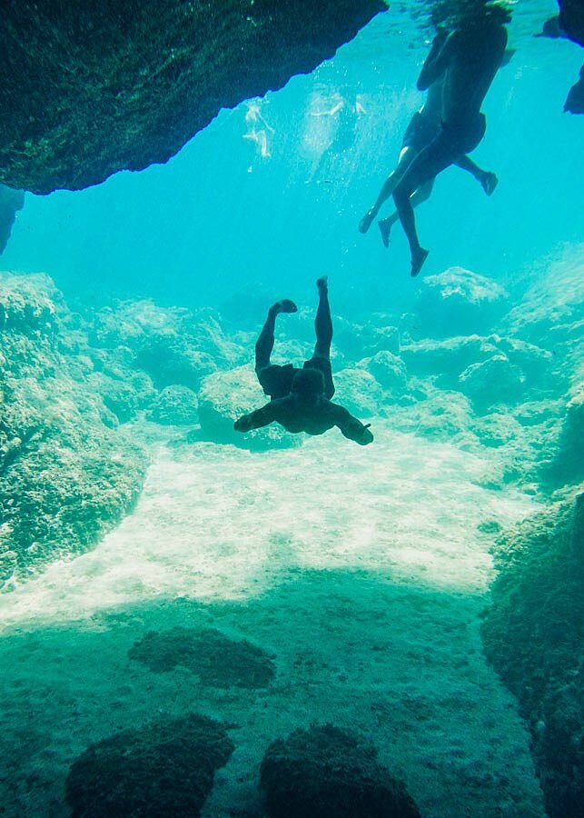 Swimmers in the blue water of a sea cave in Croatia