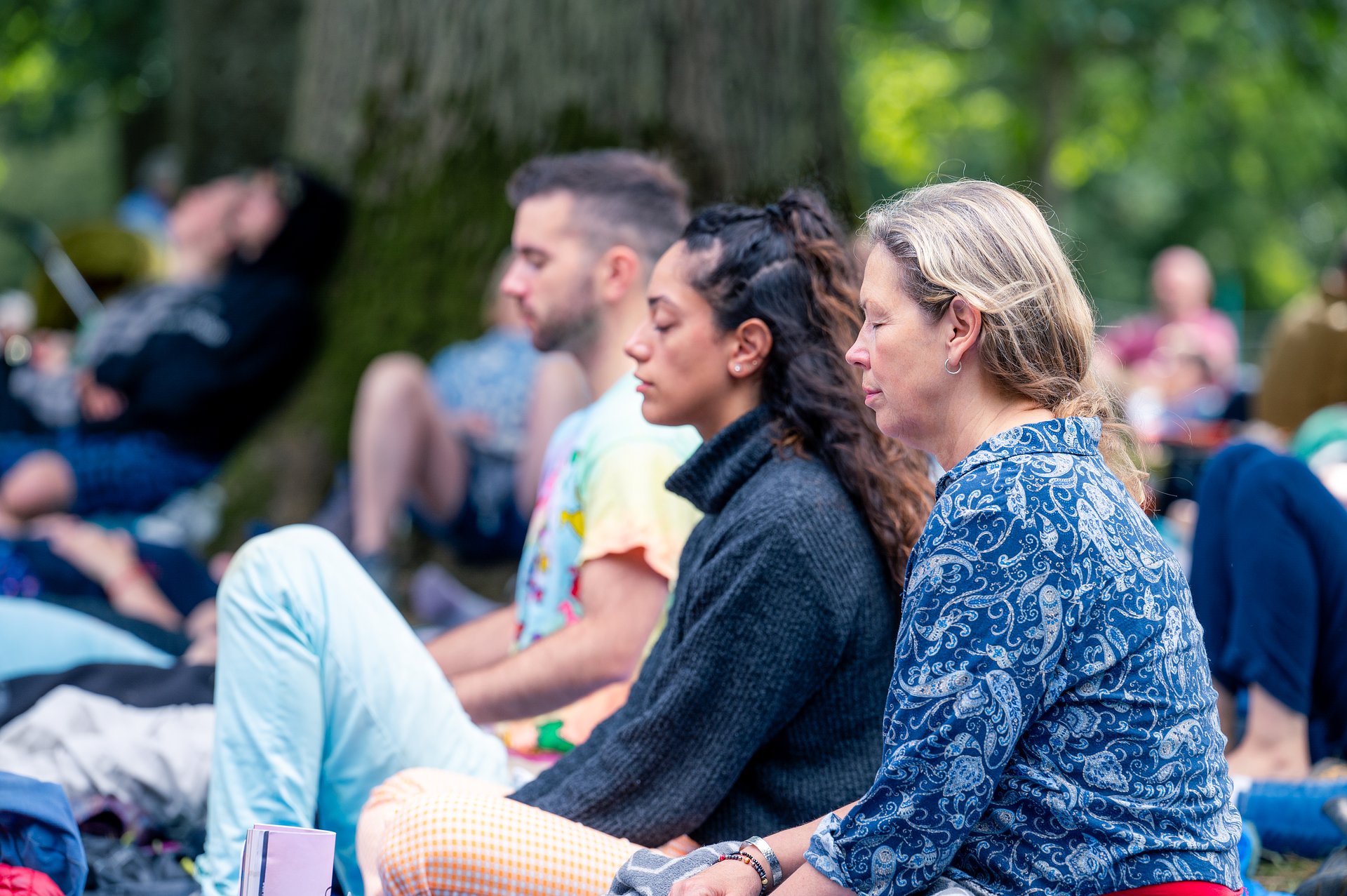People sat with their eyes closed taking part in a breathwork workshop