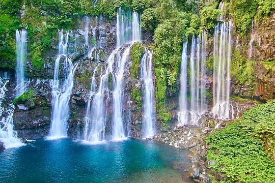 Swim beneath a roaring cascade in the lush rainforests of Reunion