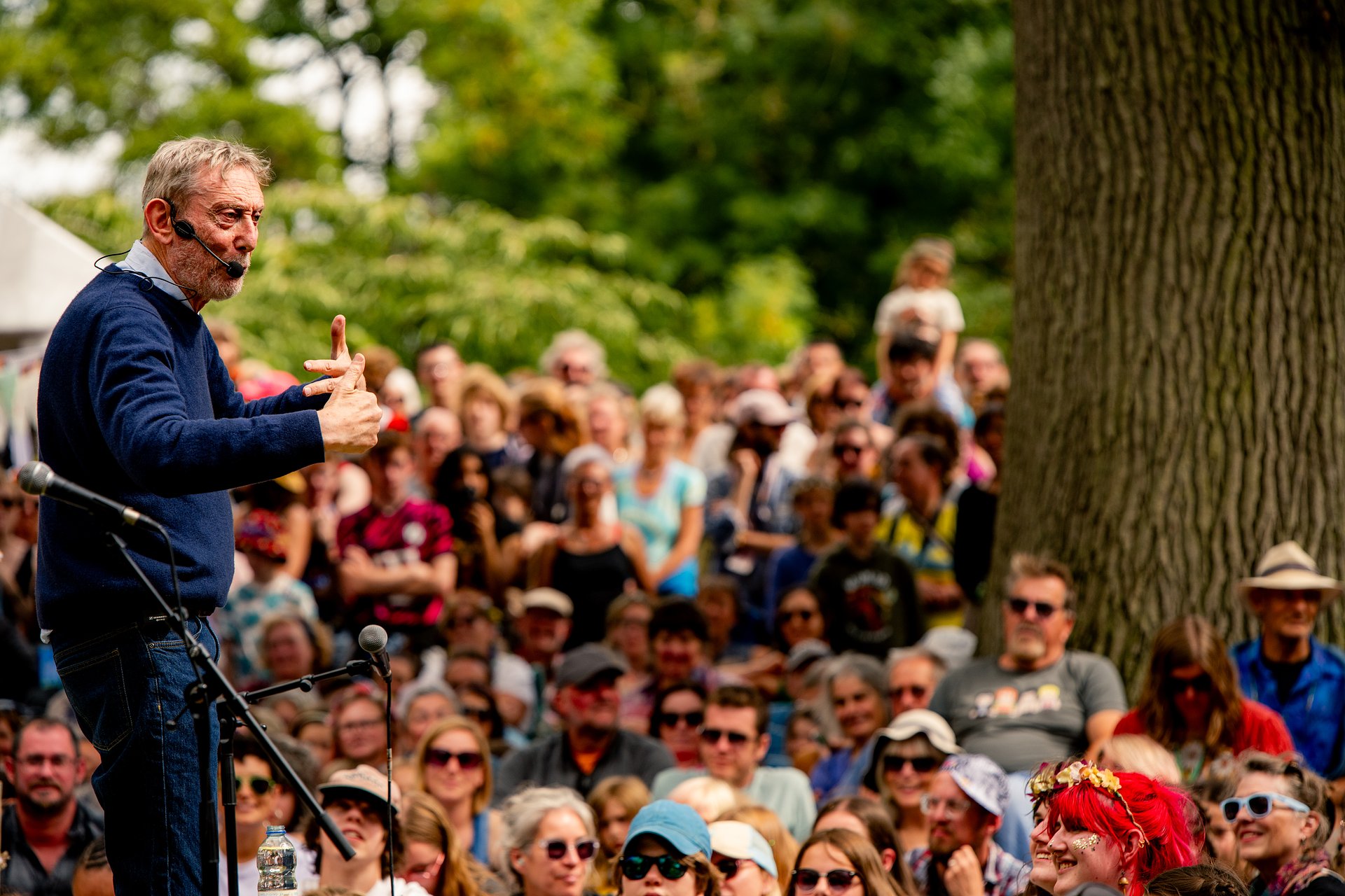 Michael Rosenstood in front of a large crowd  performing his poetry