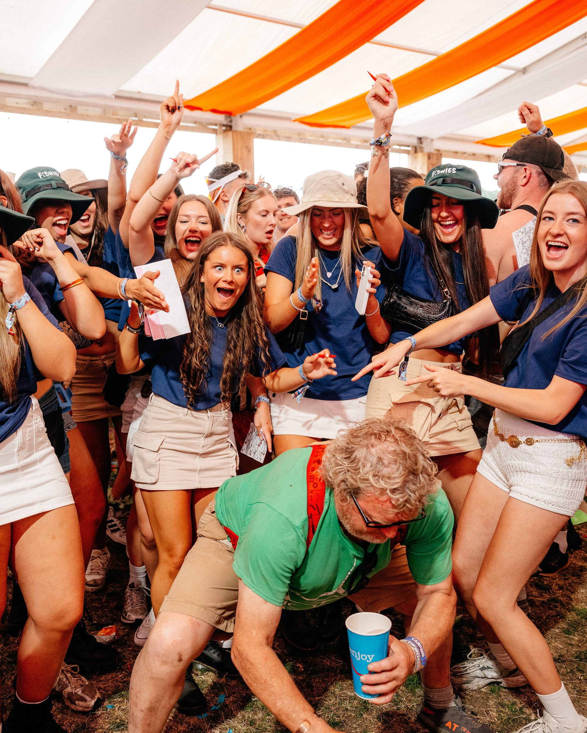 Group of girls play Bingo Lingo as man twerks in front of them in the Beer Tent at Bournemouth 7s Festival in Dorset