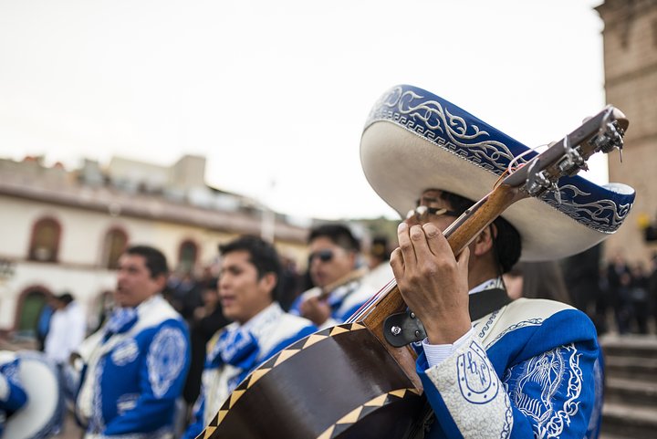 mariachimusicianstrummingaguitarwithagroup20250404235521utc