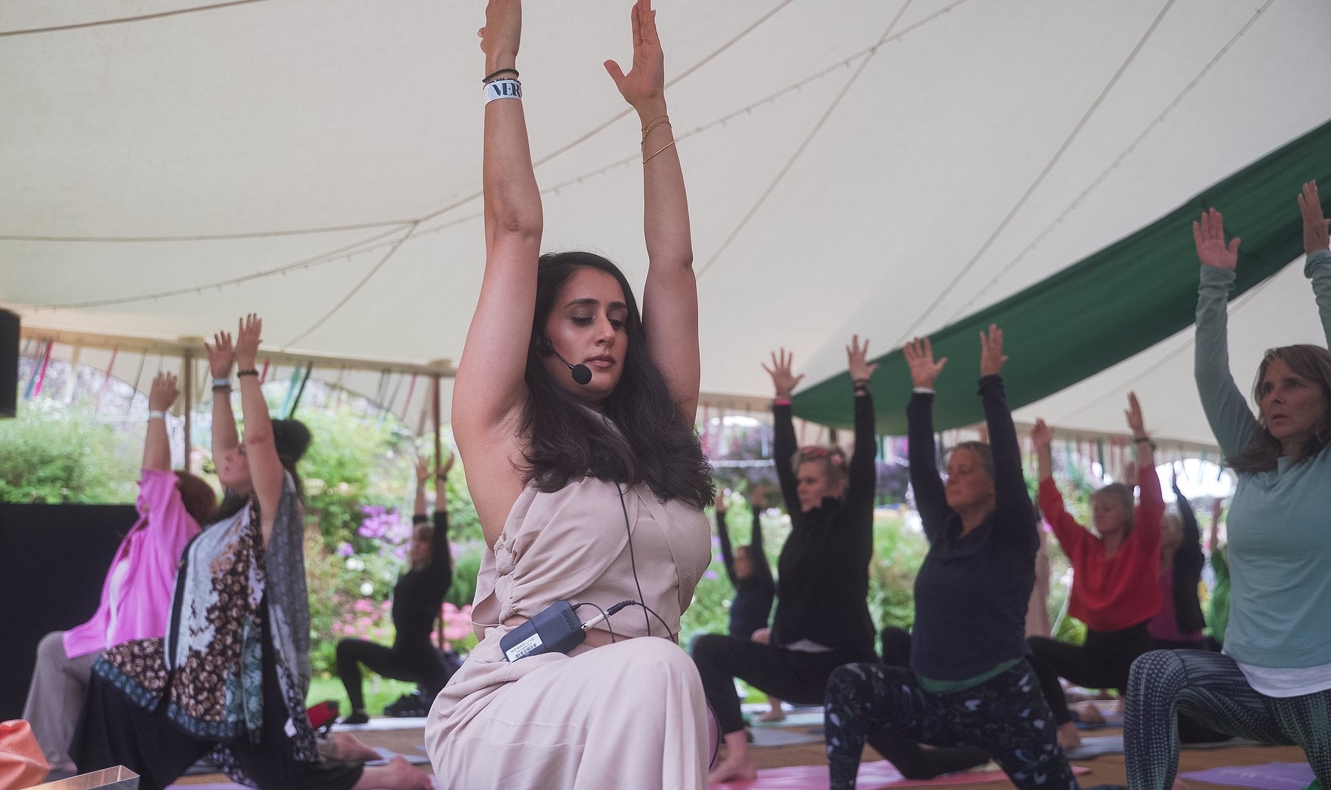 A group taking part in a yoga class inside a marquee at VERVE