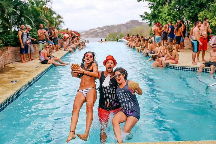 3 people falling over backwards into a pool surrounded by people in san juan del sur nicaragua sunday funday