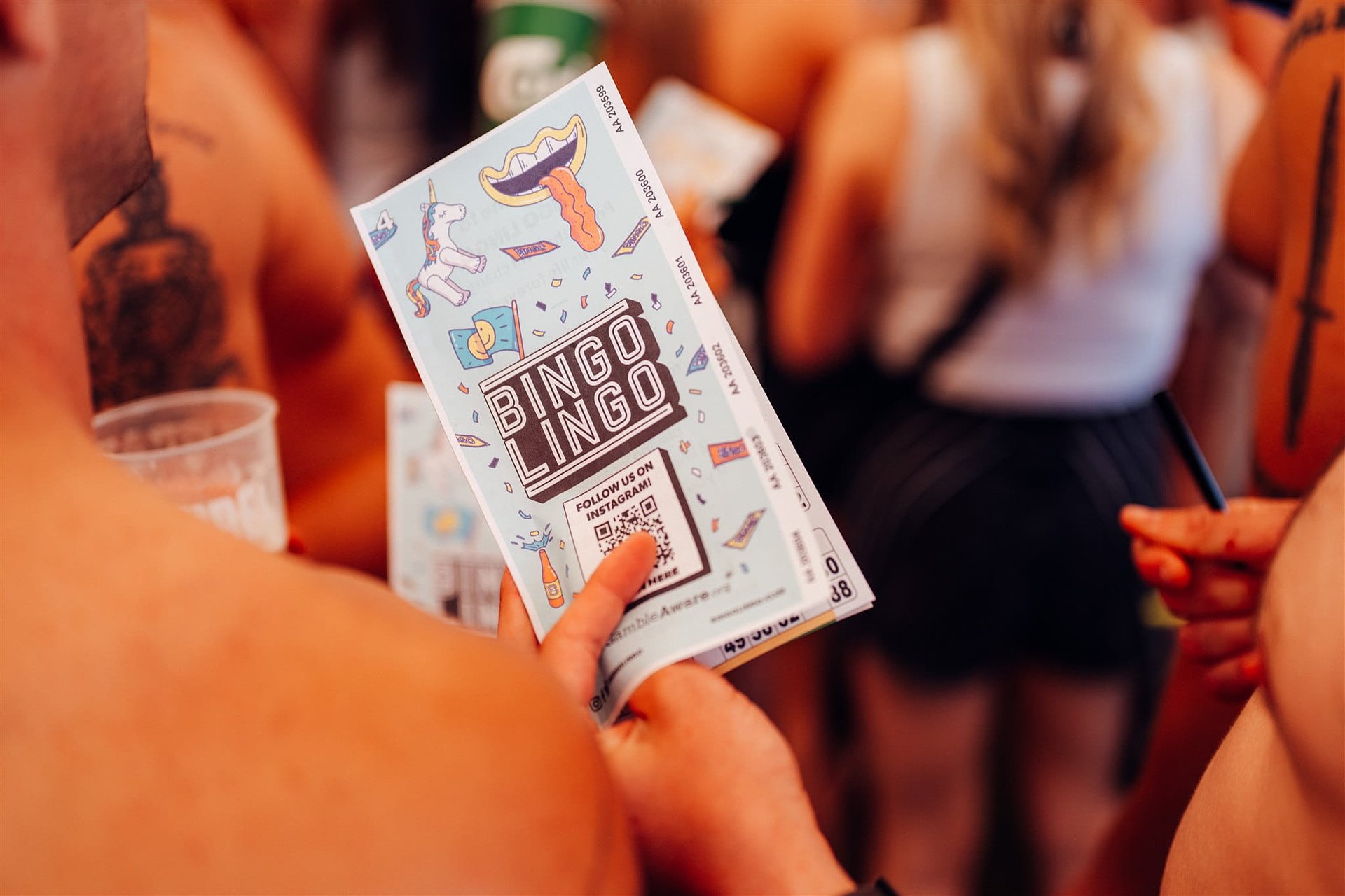 Holding a bingo lingo card at the Friday Opening Party in the Beer Tent by Jubel at Bournemouth 7s Festival in Dorset