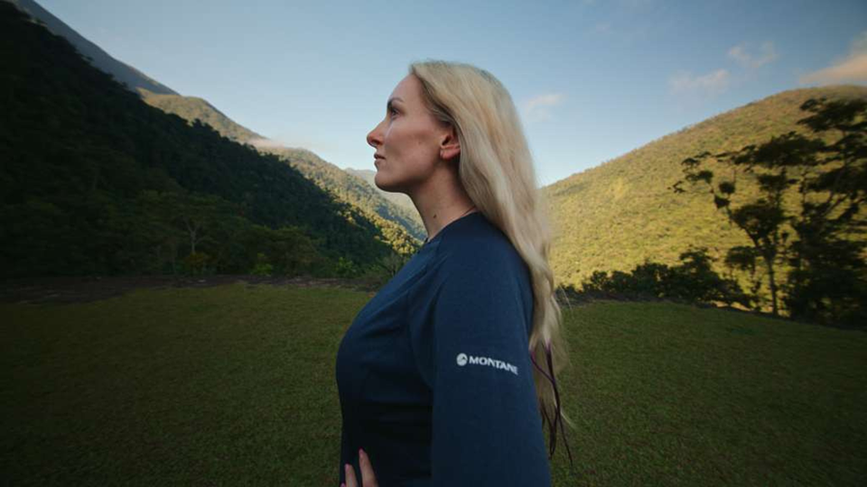 An adventurer in Montane kit in a green valley